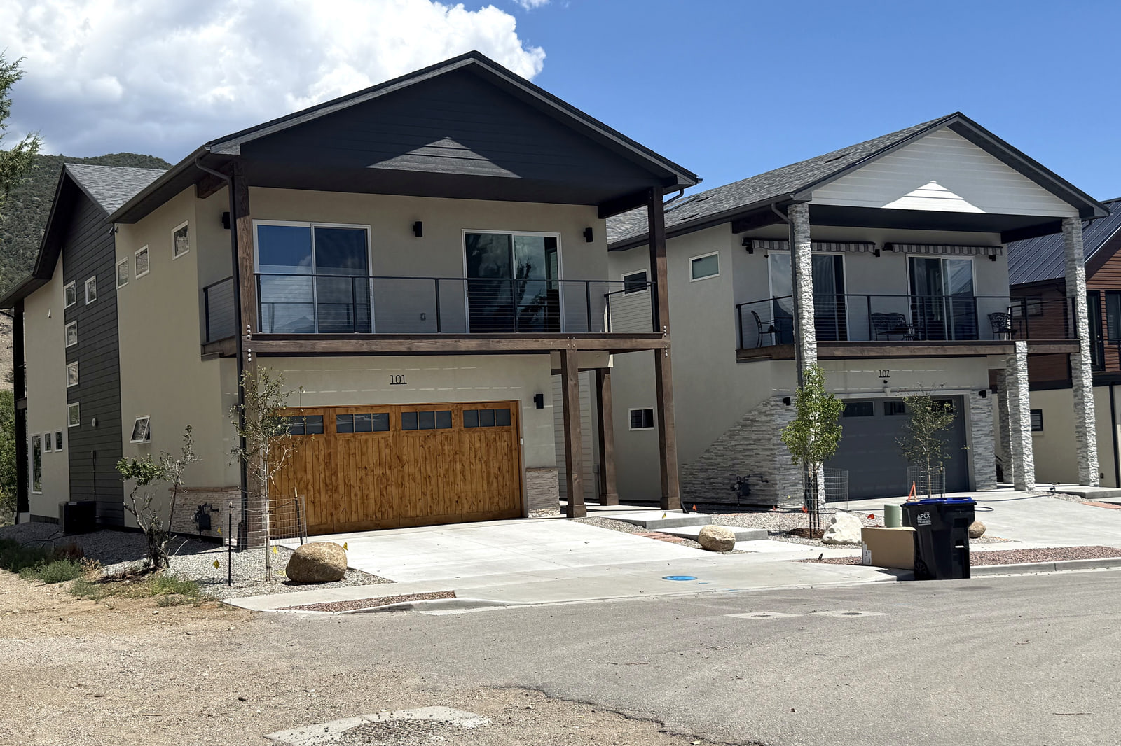 Pair of neighboring contemporary homes with elevated decks and mountain-inspired exterior materials.