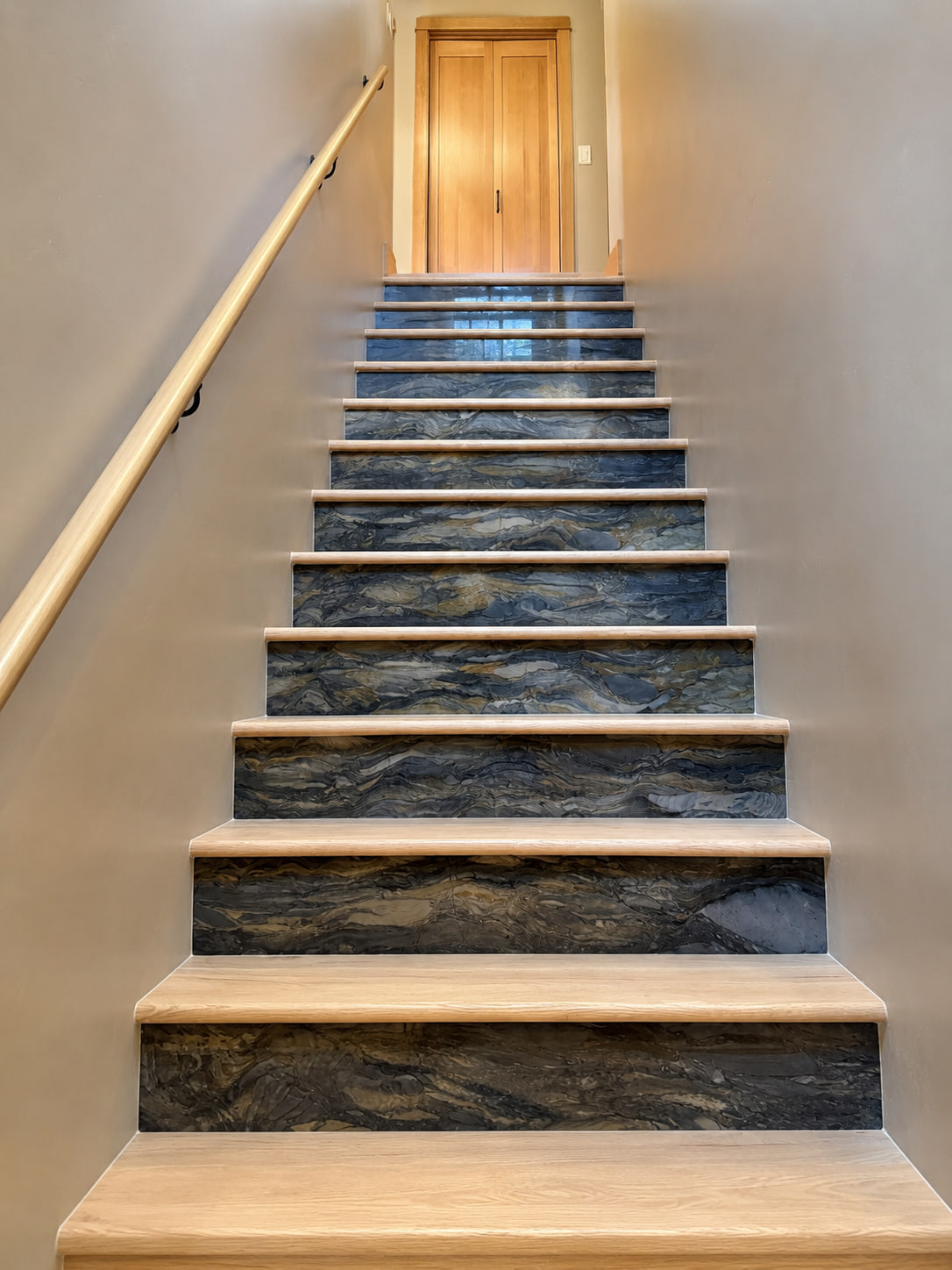 Interior staircase with natural wood treads and dark stone-patterned risers.