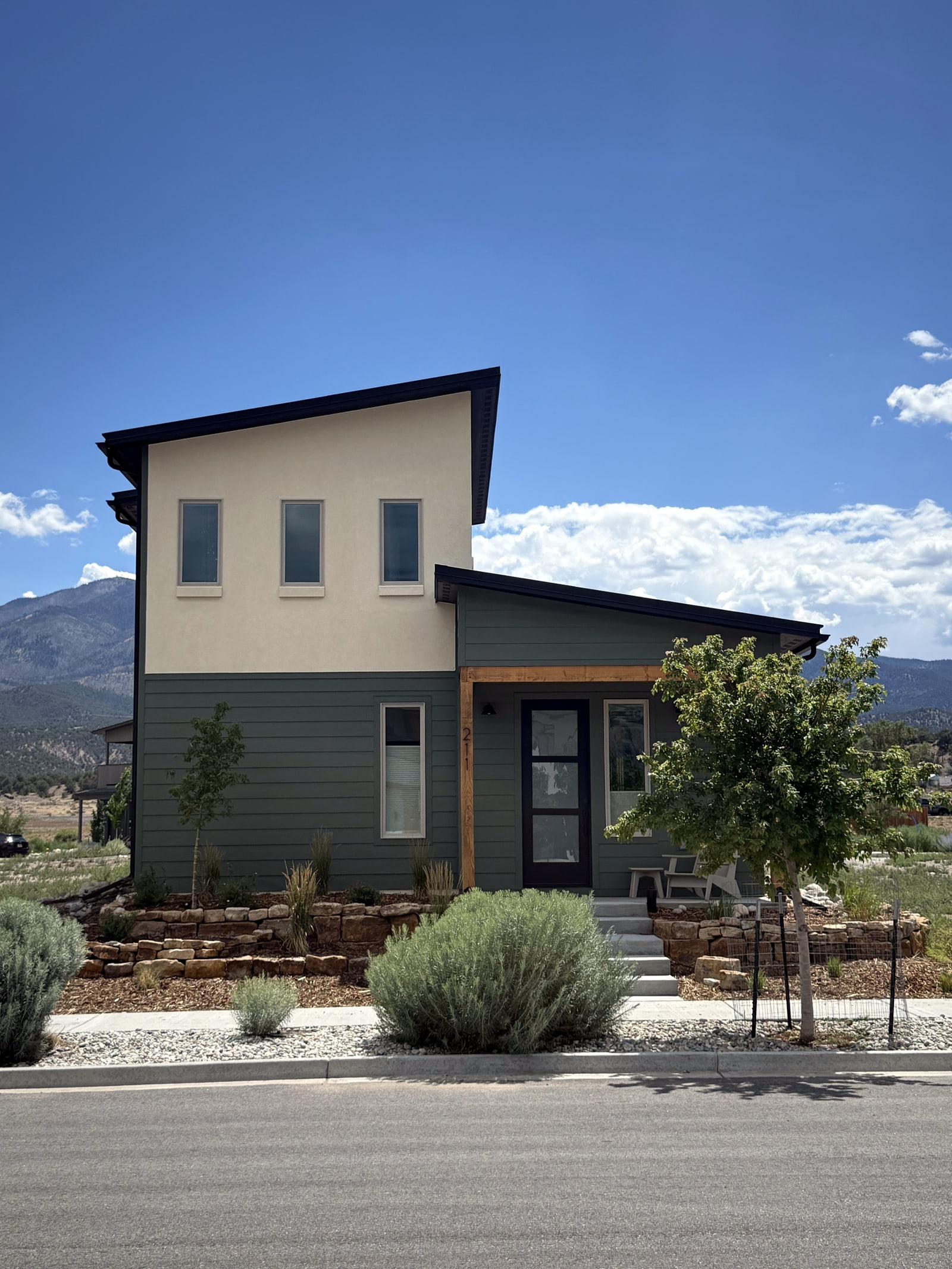 Front elevation of a contemporary Salida home with stucco, horizontal siding, and warm wood accents.