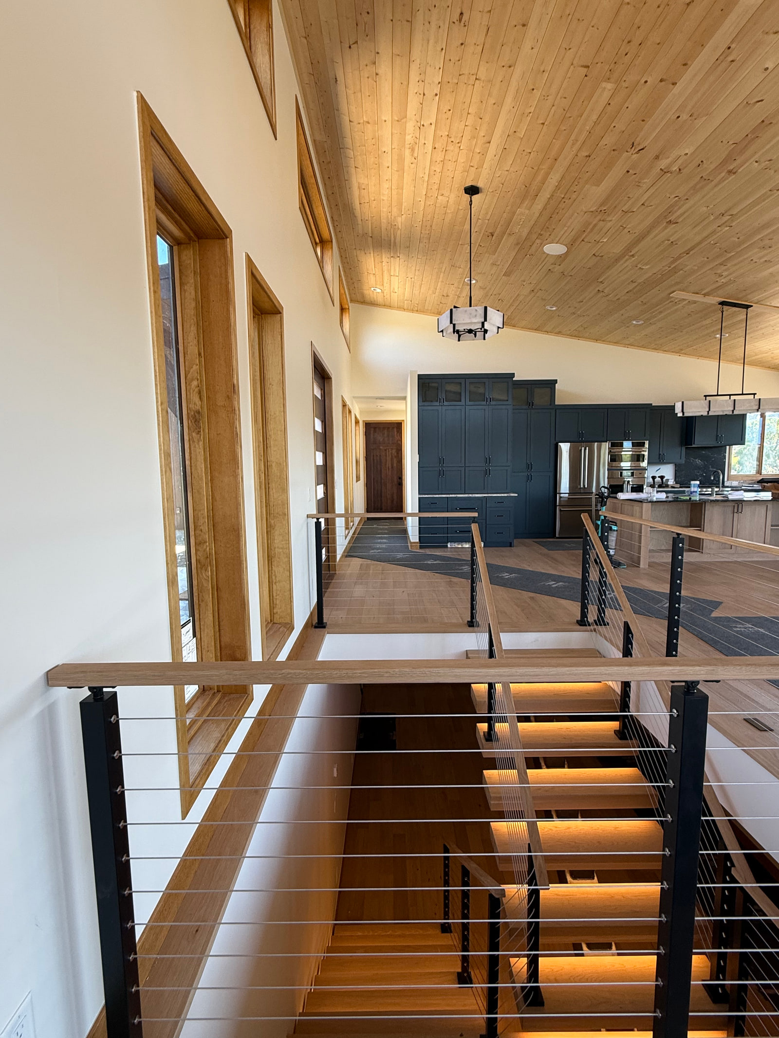 Upper-level view of the open stair beside the kitchen and great room.