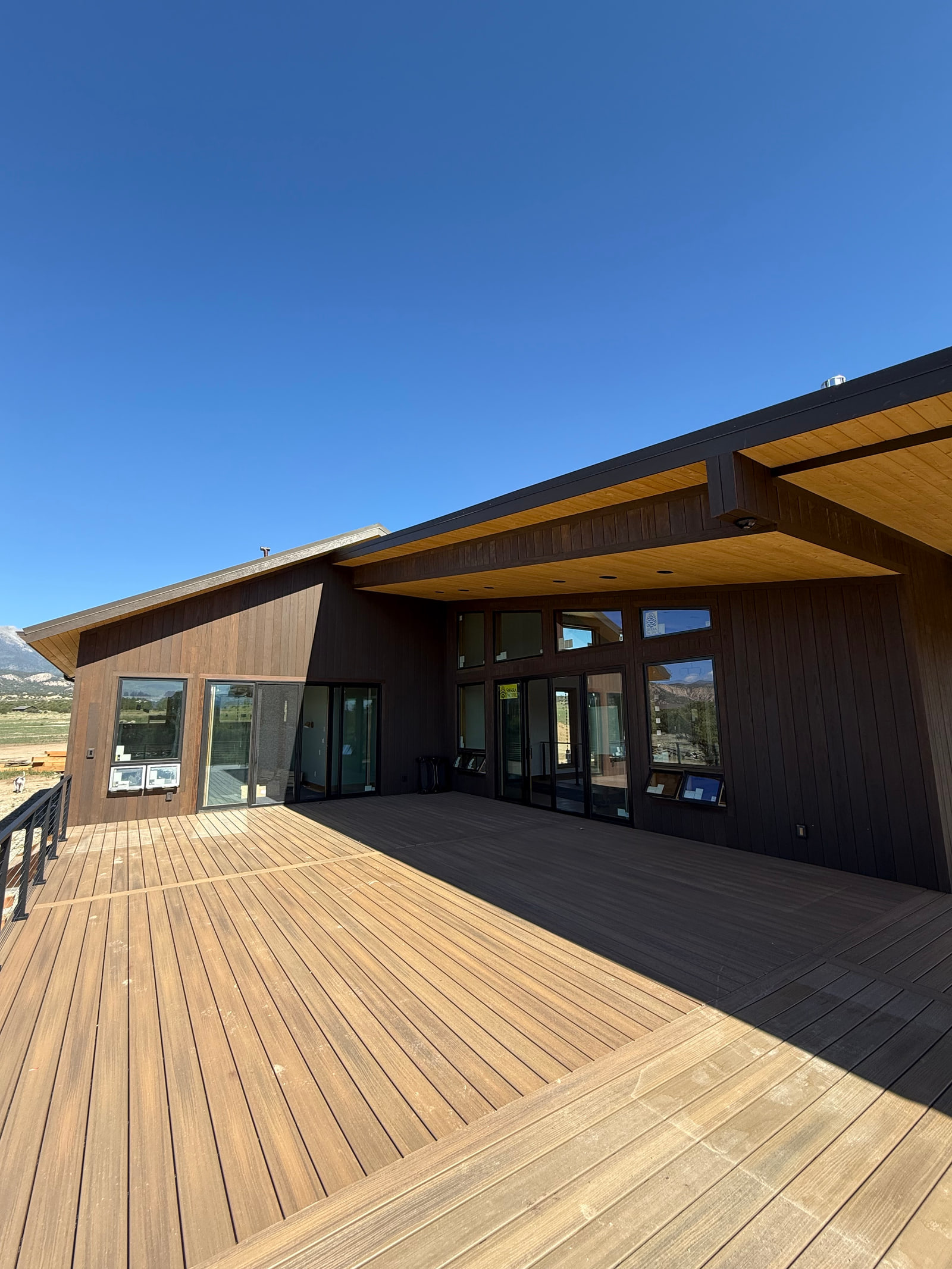 Expansive main-level deck beneath deep roof overhangs.