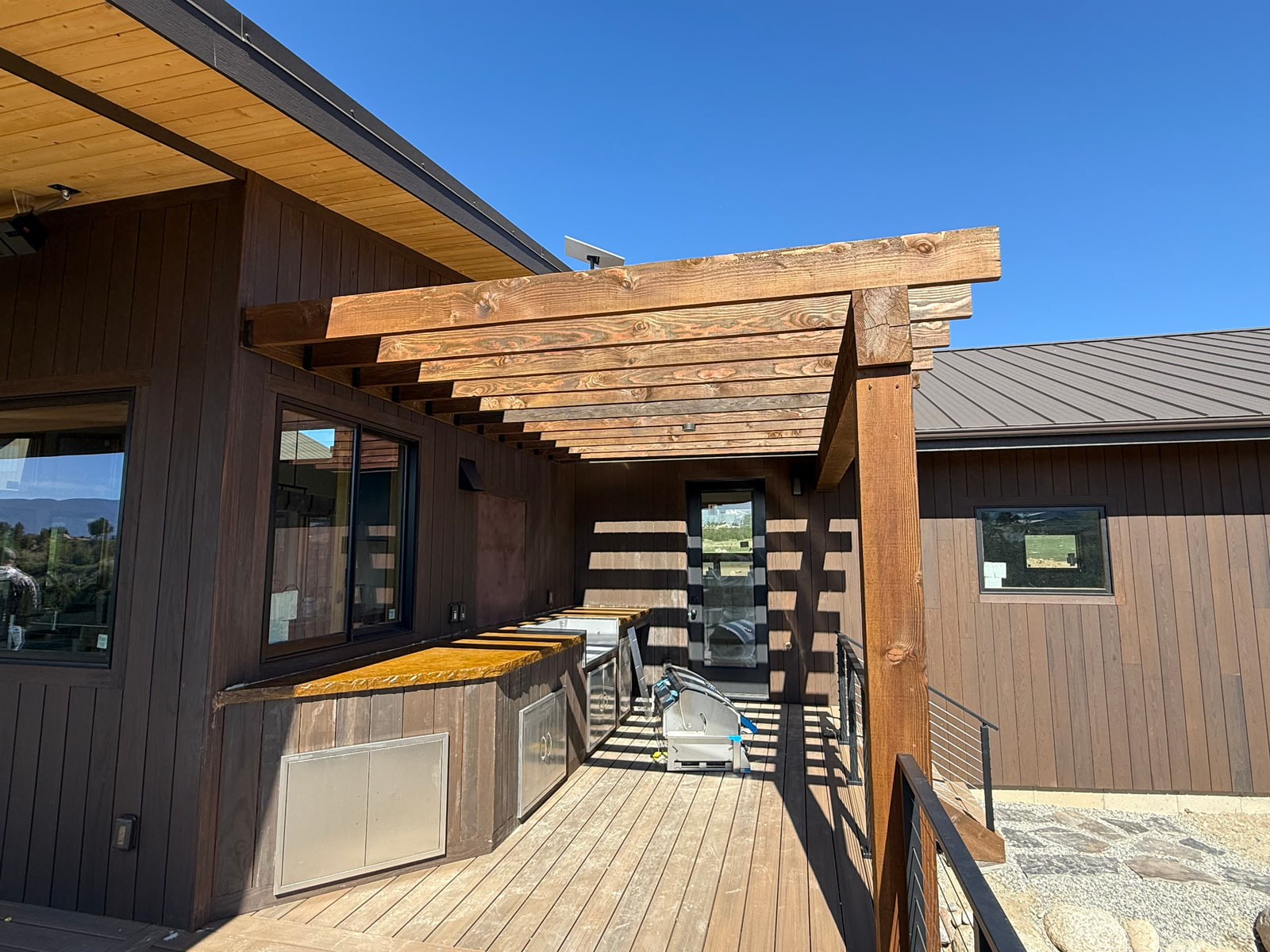 Pergola and outdoor kitchen area connected to the main living spaces.