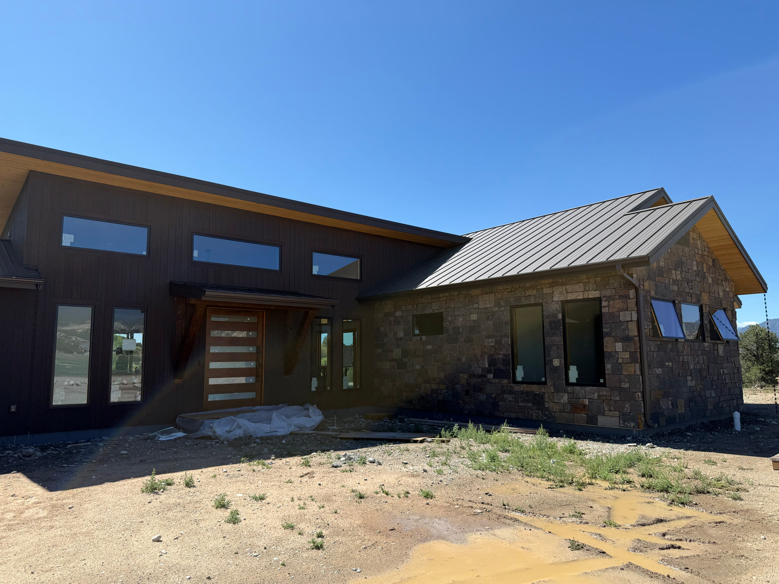 Three-quarter view of the front entry and stone-clad wing at Riverside Boathouse Overlook.
